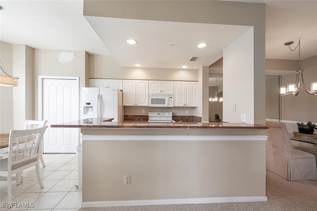 kitchen featuring white cabinets, kitchen peninsula, white appliances, decorative light fixtures, and light carpet