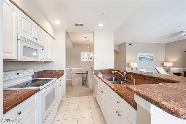 kitchen with hanging light fixtures, white cabinetry, white appliances, dark stone counters, and sink