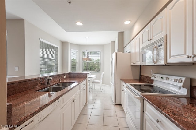 kitchen featuring sink, white appliances, decorative light fixtures, white cabinetry, and dark stone countertops