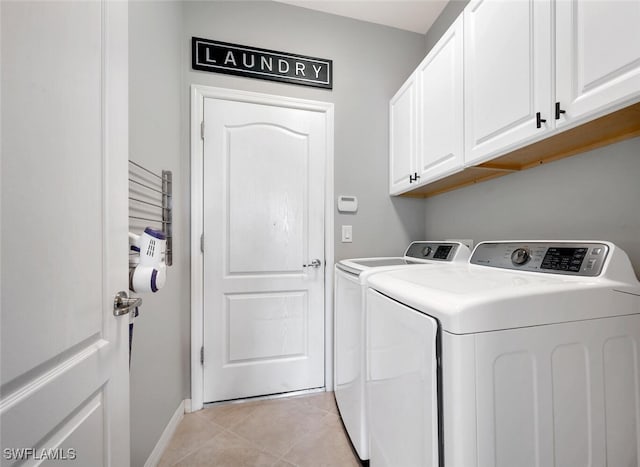 clothes washing area with separate washer and dryer, cabinets, and light tile patterned floors