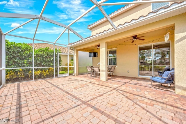 view of patio featuring a lanai and ceiling fan