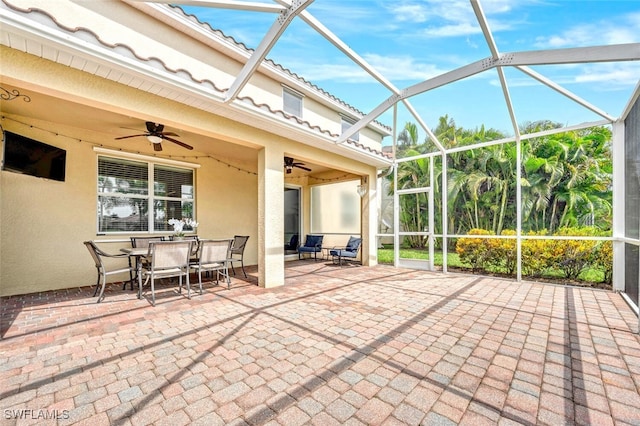 view of patio / terrace featuring ceiling fan, outdoor dining area, and a lanai