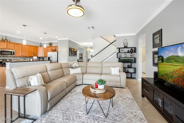 living room with ornamental molding and light tile patterned floors