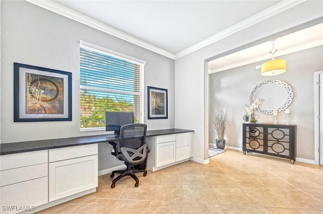 office with ornamental molding, built in desk, baseboards, and light tile patterned floors