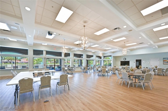 dining space featuring a notable chandelier, beamed ceiling, light hardwood / wood-style floors, and coffered ceiling