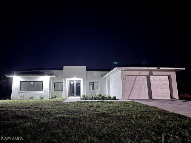 view of front of house featuring a yard and a garage