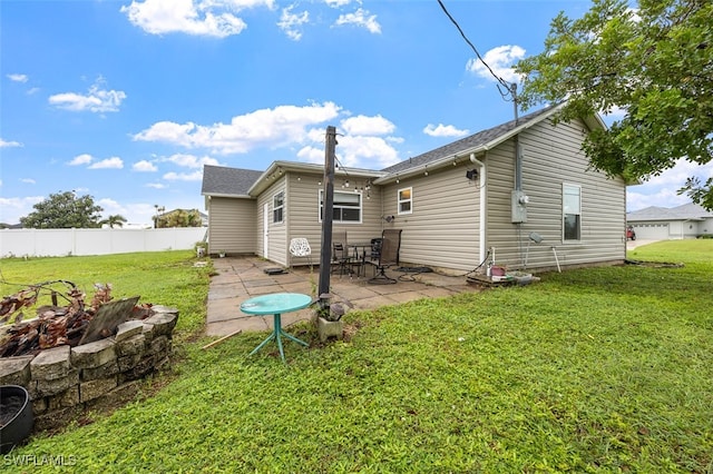 back of house with a lawn and a patio