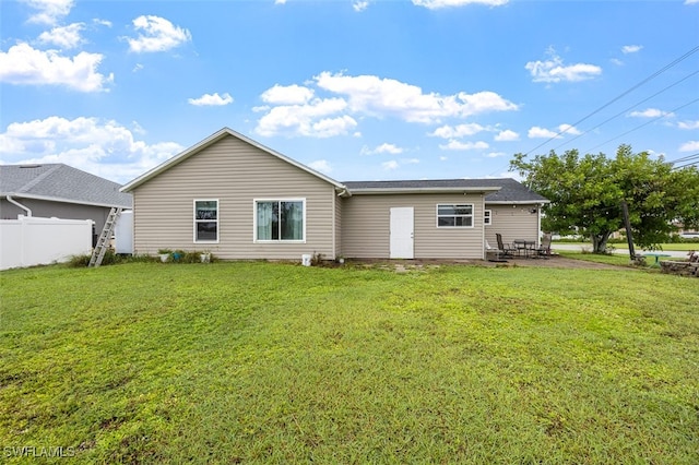 rear view of property featuring a yard