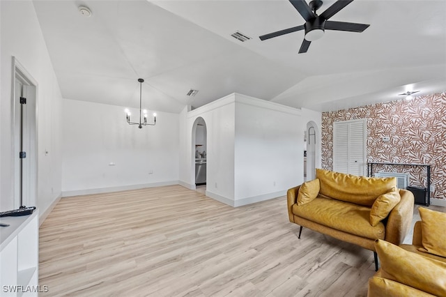 living room featuring ceiling fan with notable chandelier, lofted ceiling, and light hardwood / wood-style floors