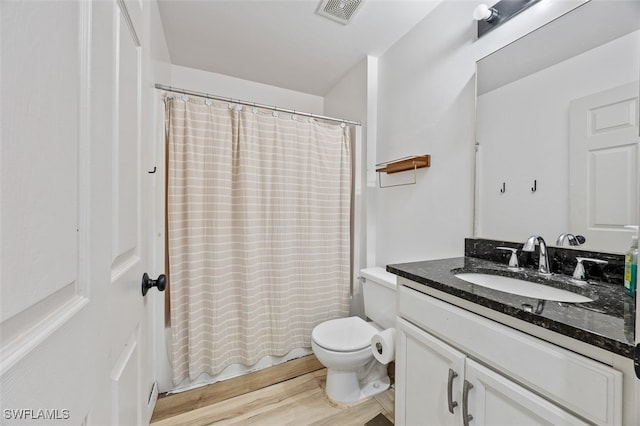 full bathroom featuring wood-type flooring, vanity, toilet, and shower / tub combo with curtain