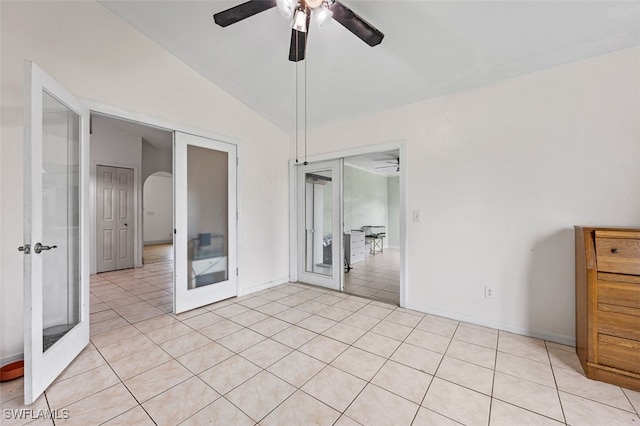 tiled empty room featuring lofted ceiling, ceiling fan, and french doors