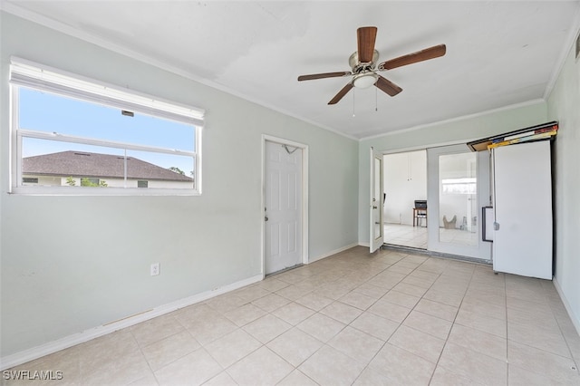 spare room with ceiling fan, crown molding, and light tile patterned floors