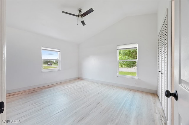 unfurnished room with light hardwood / wood-style floors, vaulted ceiling, ceiling fan, and plenty of natural light