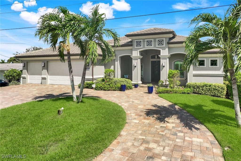 mediterranean / spanish house featuring a front yard and a garage