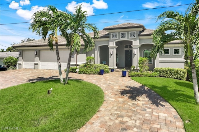 mediterranean / spanish house featuring a front yard and a garage