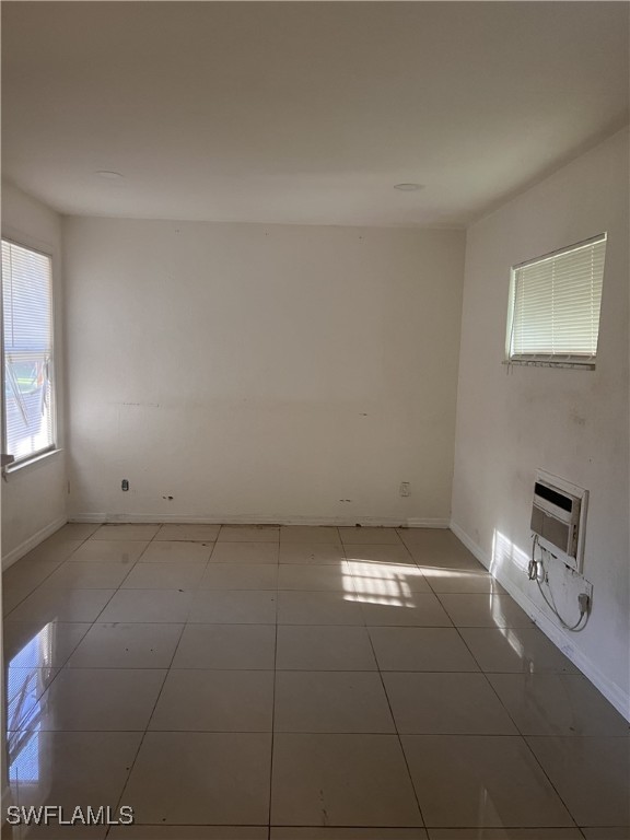 spare room with heating unit and light tile patterned floors