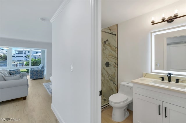 bathroom with toilet, a shower with shower door, crown molding, vanity, and hardwood / wood-style floors