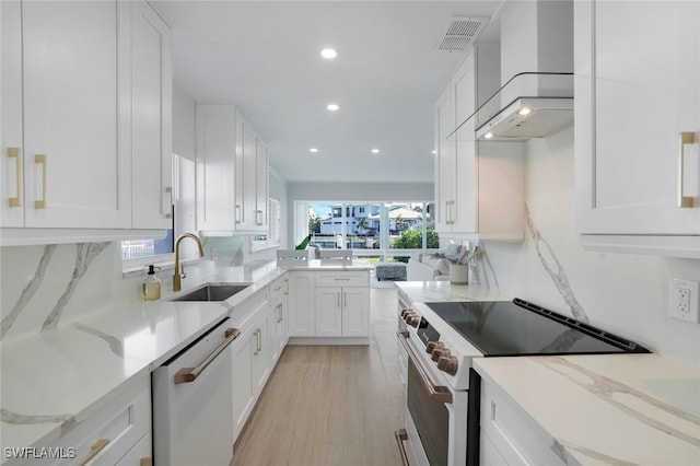 kitchen featuring sink, white cabinets, dishwashing machine, high end white range oven, and light stone countertops