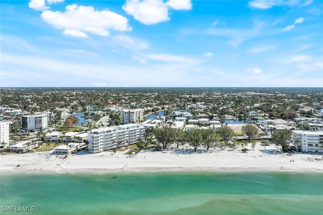 birds eye view of property featuring a water view and a beach view