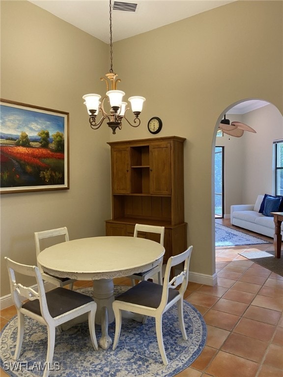 tiled dining space featuring ceiling fan with notable chandelier and high vaulted ceiling