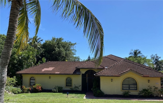 mediterranean / spanish-style house with a front yard