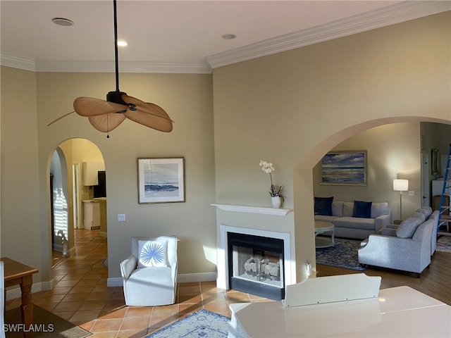 tiled living room with ornamental molding and ceiling fan