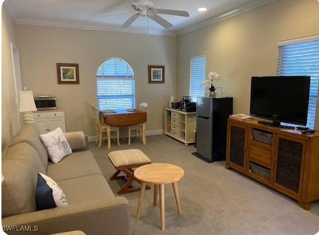 carpeted living room featuring crown molding and ceiling fan