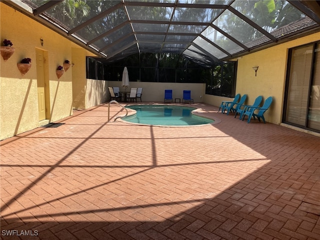 view of swimming pool with glass enclosure and a patio area