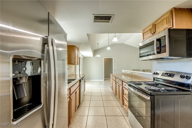 kitchen featuring light tile patterned floors, decorative light fixtures, vaulted ceiling, and stainless steel appliances