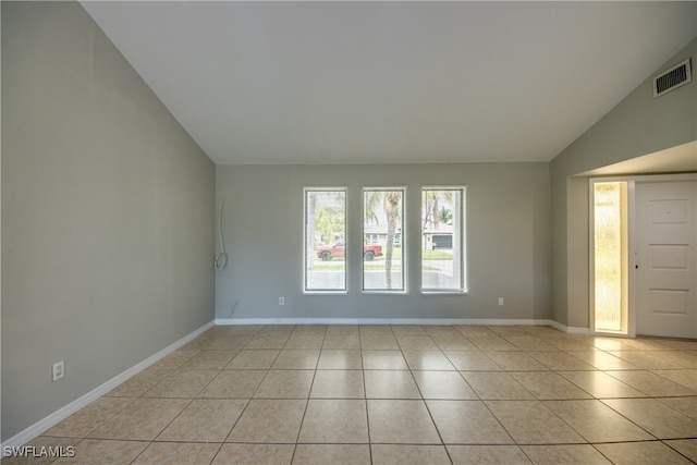 tiled empty room with lofted ceiling