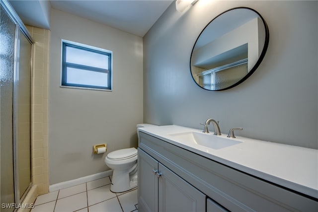 bathroom featuring tile patterned flooring, vanity, a shower with door, and toilet