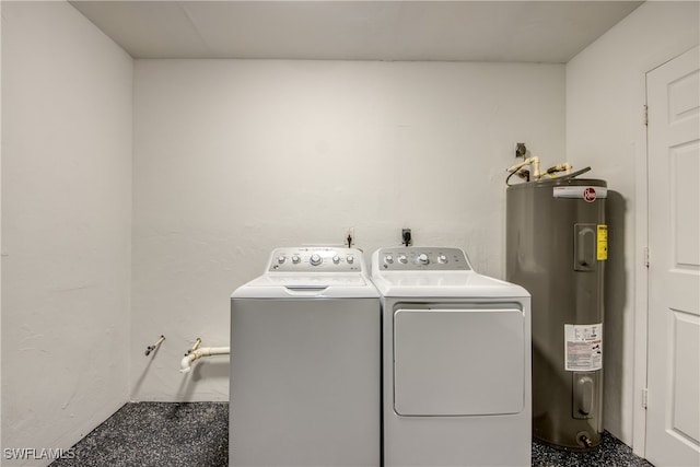 washroom with washing machine and clothes dryer and electric water heater