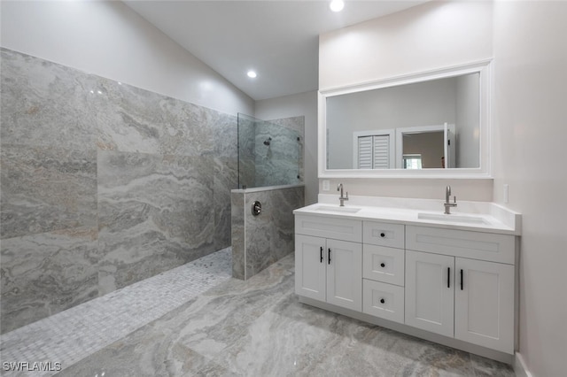 bathroom featuring vanity, lofted ceiling, and tiled shower