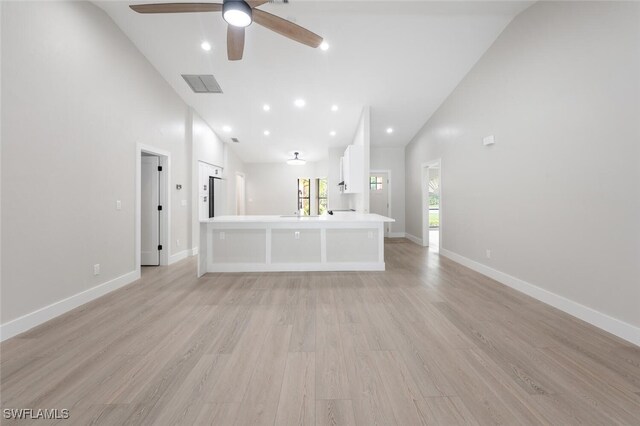 unfurnished living room featuring ceiling fan, high vaulted ceiling, and light hardwood / wood-style floors