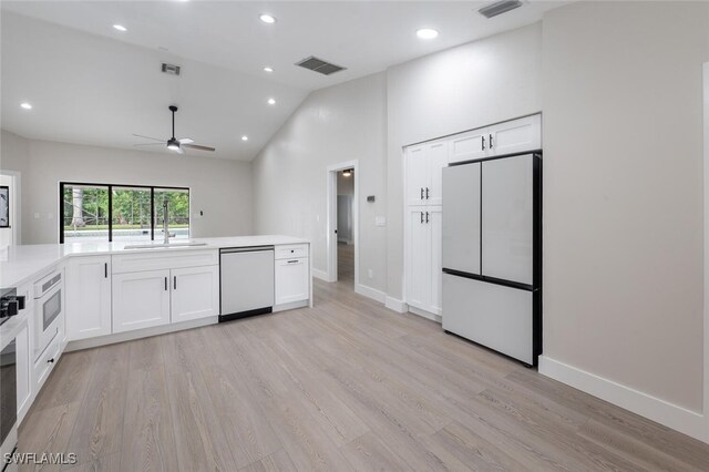 kitchen with white cabinetry, white appliances, and light hardwood / wood-style flooring