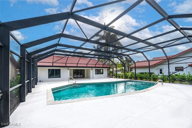 view of pool with glass enclosure and a patio