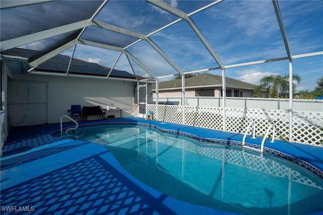 view of pool with glass enclosure and a patio area