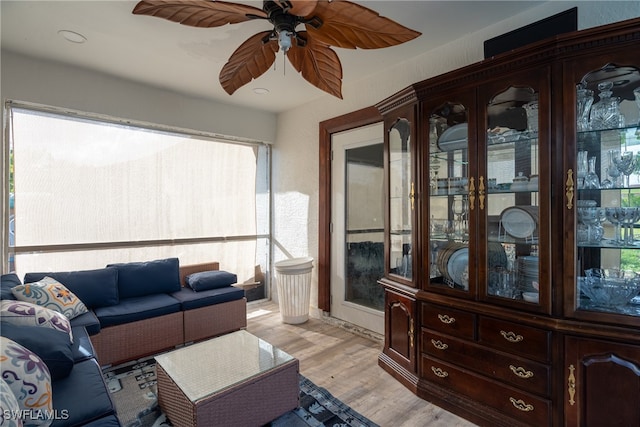 living room featuring light wood-type flooring and ceiling fan