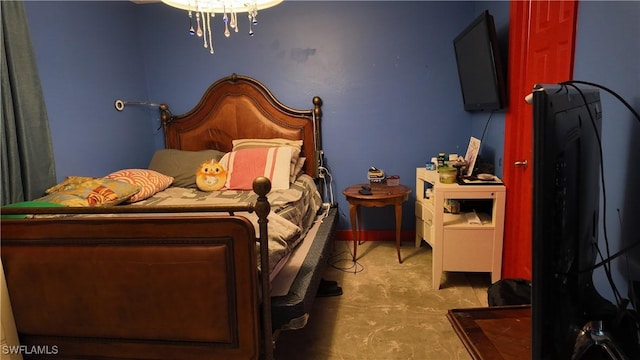 bedroom featuring a chandelier and concrete floors