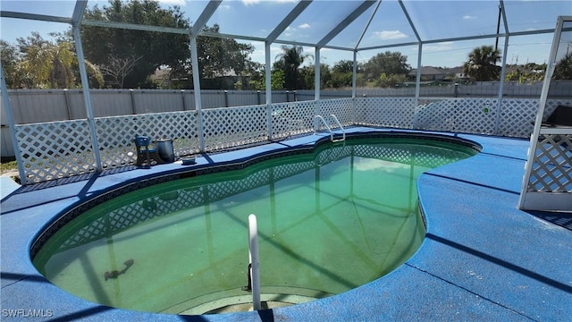 view of swimming pool featuring fence, a fenced in pool, a patio area, and a lanai