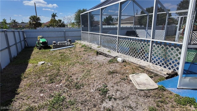 view of yard featuring a fenced backyard and a lanai