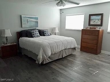 bedroom featuring ceiling fan, hardwood / wood-style floors, and a textured ceiling