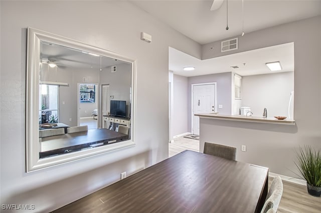 dining area with light wood-type flooring and ceiling fan