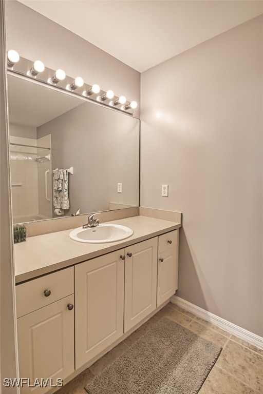 bathroom with vanity, tile patterned floors, and tiled shower