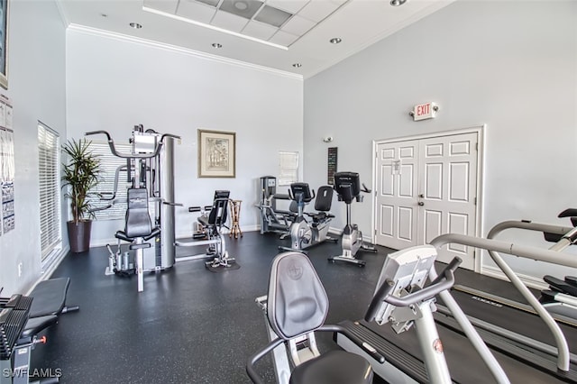 gym with a towering ceiling and ornamental molding