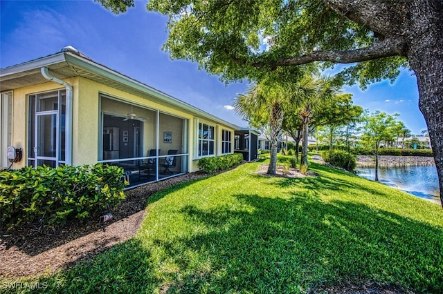 view of yard featuring ceiling fan and a water view