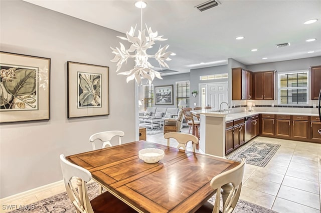 tiled dining room featuring sink and a notable chandelier