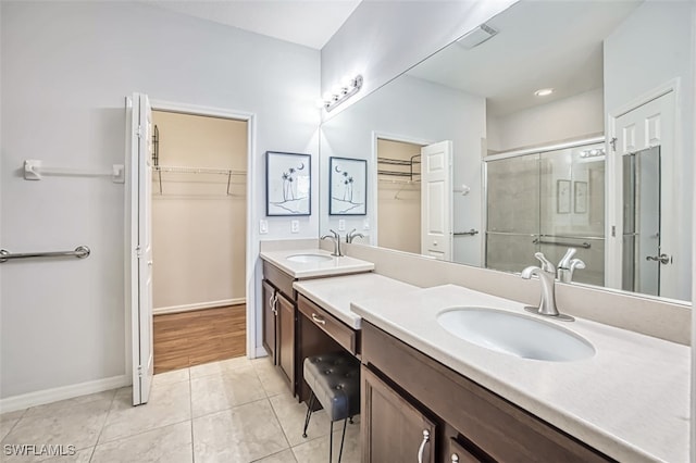 bathroom featuring tile patterned floors, a shower with shower door, and vanity