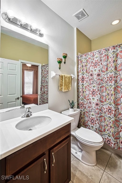 bathroom with vanity, tile patterned flooring, toilet, and a textured ceiling