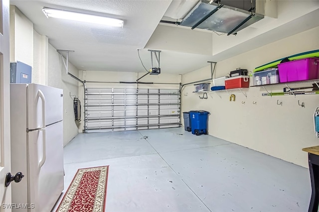 garage with a garage door opener and white fridge